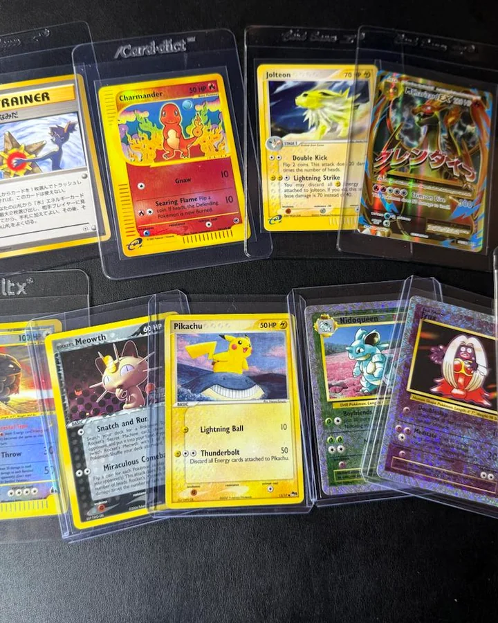 Pokemon singles protected in card holders on a black surface